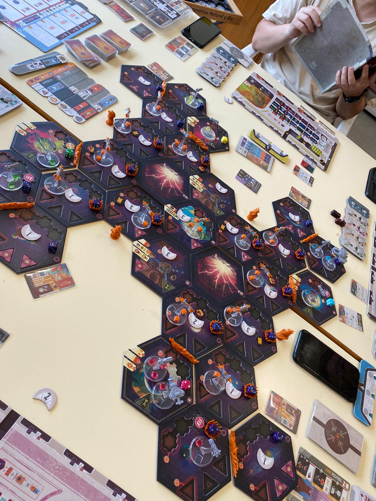 Mesa de juego con tablero, miniaturas y componentes