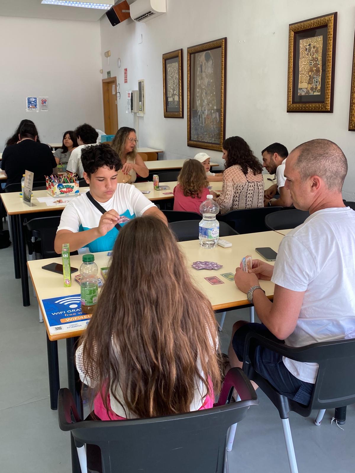 Mesa con juego de mesa y jugadores leyendo reglas